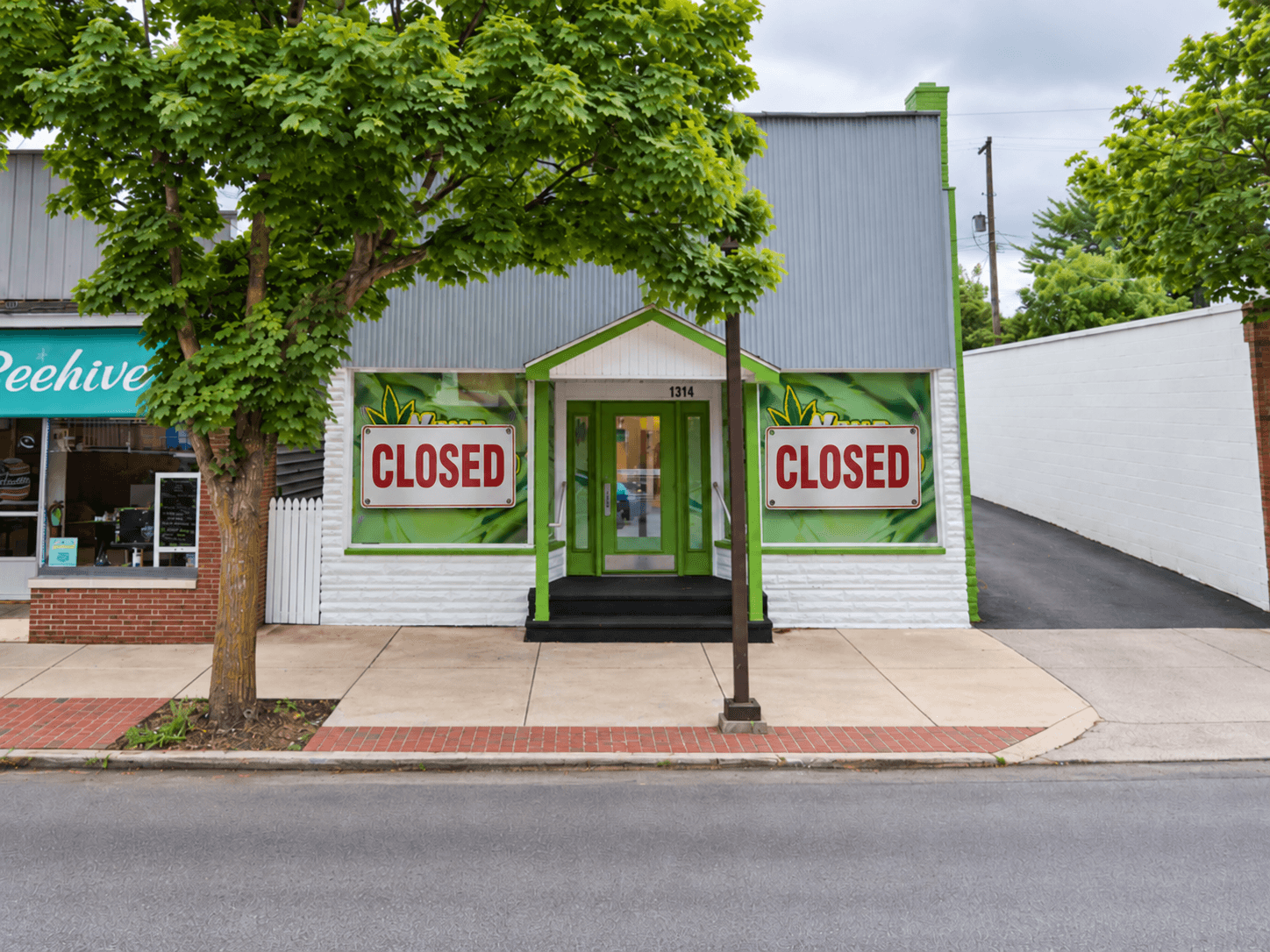 Closed Xhale Cannabis Co. storefront in Bay City, Michigan, with closed signs covering the front windows.